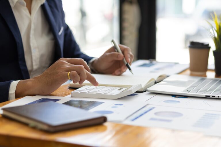 someone working with financial data with coffee and laptop on table